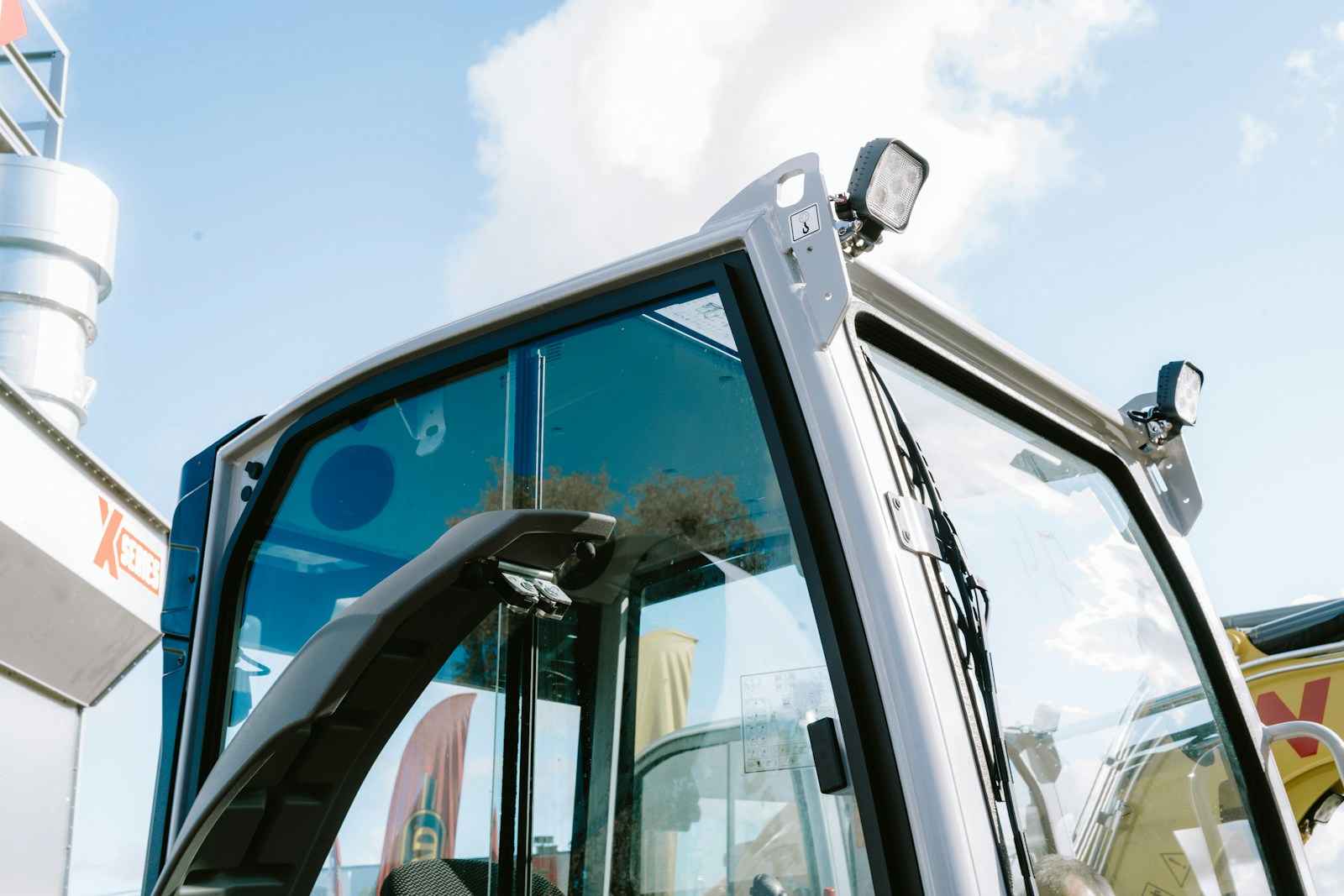 Close-up of a modern excavator cabin under blue sky